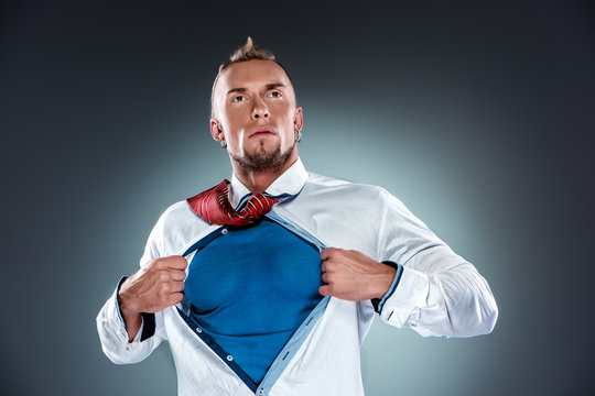 businessman acting like a super hero and tearing his shirt off