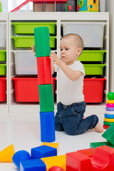 Fototapeta na wymiar child builds a tower of cubes