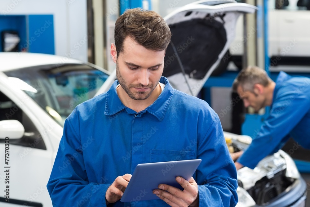 Poster smiling mechanic using a tablet pc