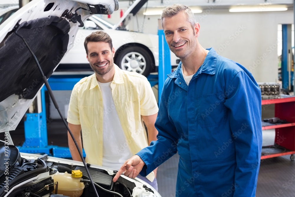 Poster mechanic showing customer the problem with car