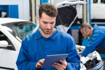 Smiling mechanic using a tablet pc