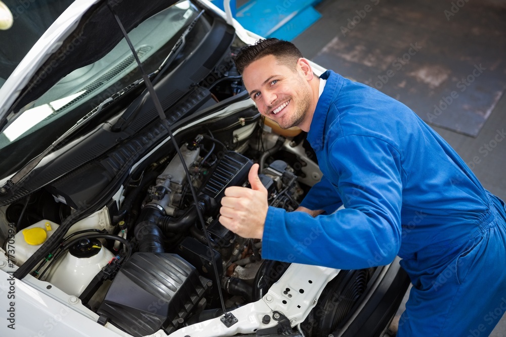 Wall mural mechanic examining under hood of car