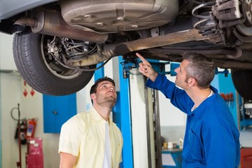 Obraz na płótnie Canvas Mechanic showing customer the problem with car