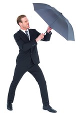 Businessman holding umbrella to protect himself