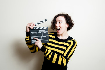 Smiling girl with movie clapper on white background