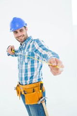 Happy repairman looking at measure tape