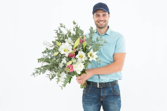 Happy delivery man holding bouquet
