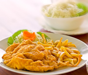 French fries with breaded meat and salad