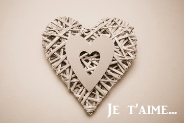 Composite image of wicker heart ornament with paper cut out