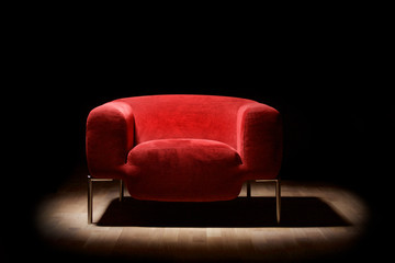 Red alcantara armchair on a black background - obrazy, fototapety, plakaty
