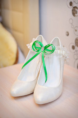 Obraz na płótnie Canvas Luxury wedding shoes. Elegant bridal shoes and a white garter