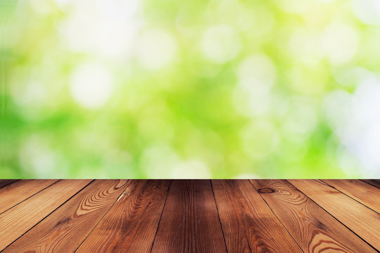 Wood table and bokeh abstract nature green background