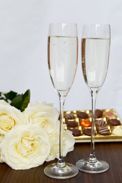 Champagne Glasses, Box of Chocolate and Bunch of White Roses