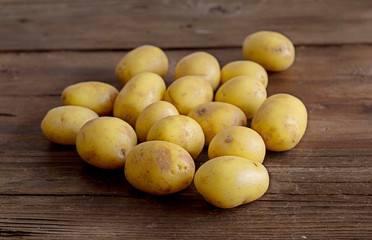 Young small potatos on wooden background