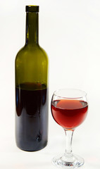 Glass with red wine and open bottle