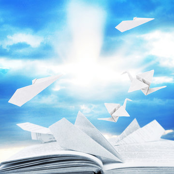 Origami Airplanes On Book On Sky Bakground