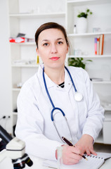 female doctor is writing prescription at the clinic