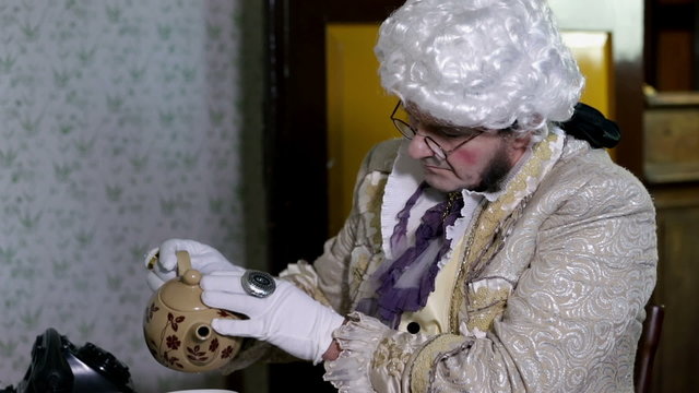 Man from enlightenment era is pouring himself a cup of tea
