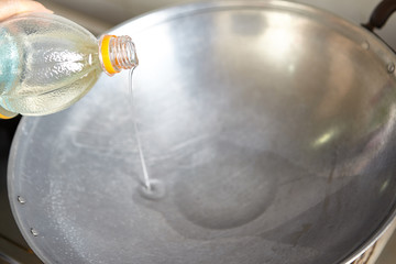 Pouring oil into the wok