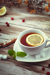 A cup of tea with lemon,cinnamon and mint leaf