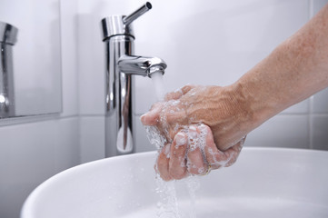 Rinse hands under a faucet with the water falling
