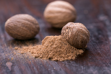 Ground nutmeg spice on the wooden background