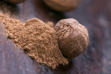 Ground nutmeg spice on the wooden background