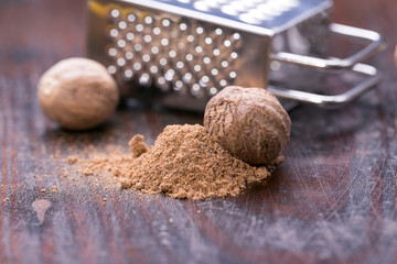 Ground nutmeg spice on the wooden background