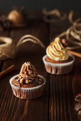 two brown chocolate cupcakes on wood background