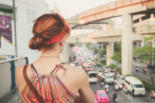 Young woman looking at traffic in Bangkok