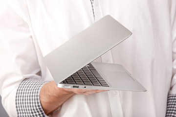 Naklejka na ściany i meble Hand holding a laptop
