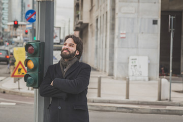 Young handsome bearded man posing in the city streets