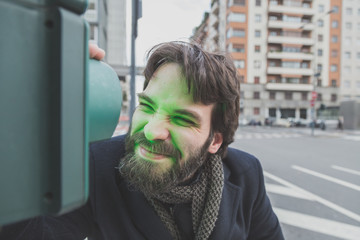 Young handsome bearded man posing in the city streets