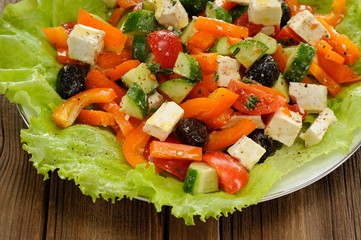 Greek salad with lettuce, olives, tomatoes, cucumbers and cheese