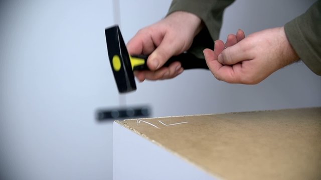 Nailing the nails into furniture with small hammer