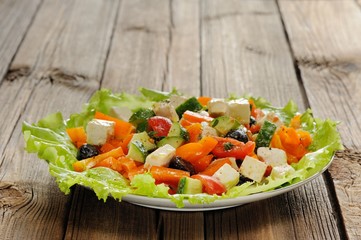 Greek salad with lettuce, olives, tomatoes, cucumbers and cheese