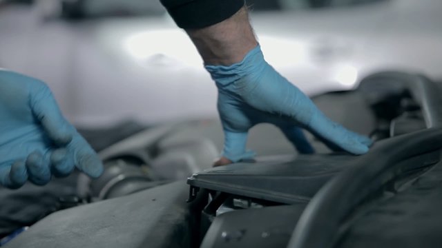 Mechanic is placing parts back in their place