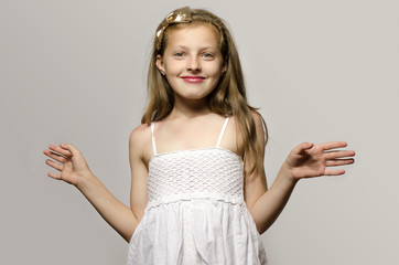 Beautiful young blonde girl in white dress smiling kid playing.