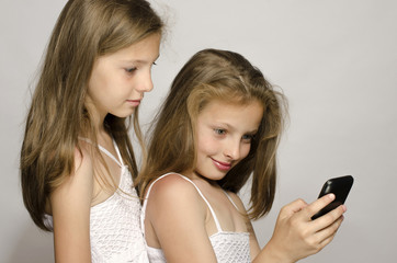 Two young girl taking a selfie, kids taking a photo, having fun