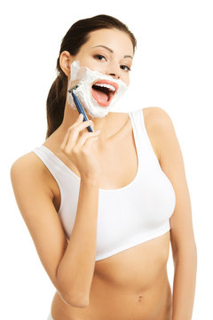 Happy woman shaving her face