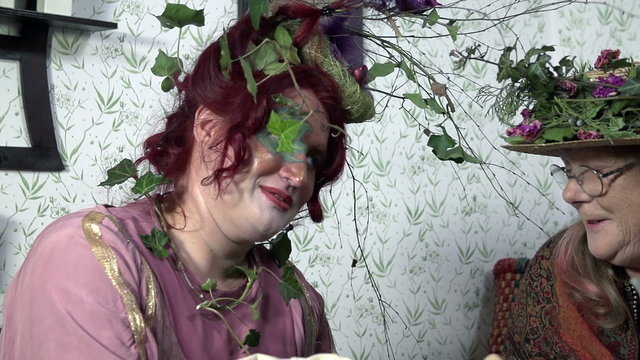 Two ladies with plant's on their hats conversating