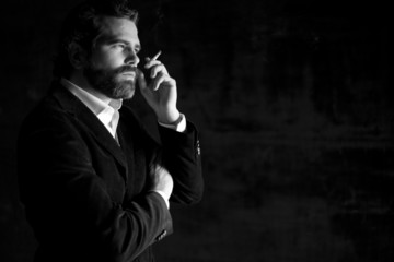 Retrato de hombre serio fumando con traje