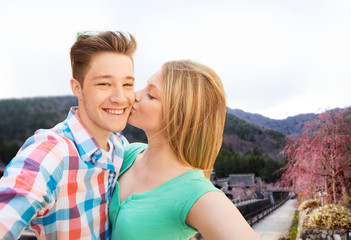 Fototapeta premium couple kissing and taking selfie over asian town