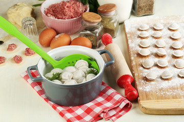 Raw and cooked dumplings close-up in kitchen