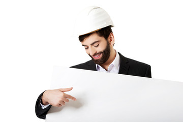 Engineer in helmet pointing on empty banner.