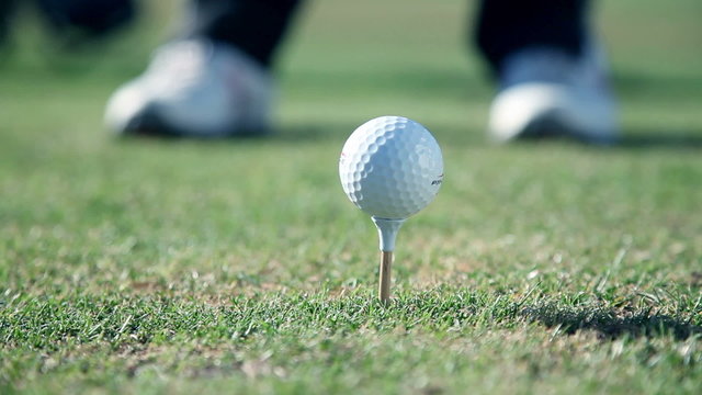 golfer walk towards a point where he sticks a white golf ball