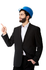 Engineer in protective helmet pointing up.