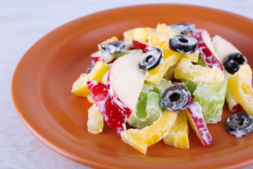 Waldorf salad with olive on plate on wooden background