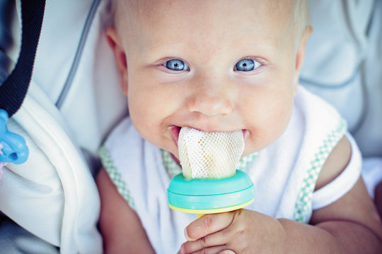 Child Eating A Banana In The Protective Grid