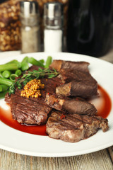 Steak with wine sauce on plate on table close up